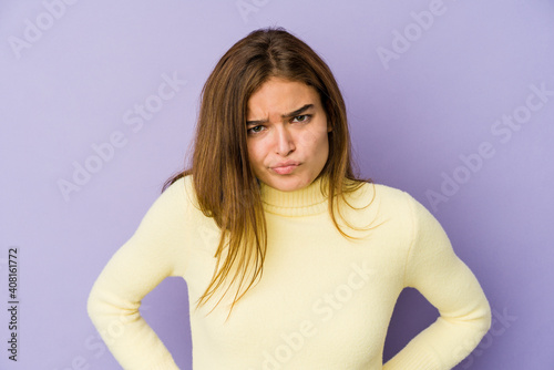 Young skinny caucasian girl teenager on purple background sad, serious face, feeling miserable and displeased.