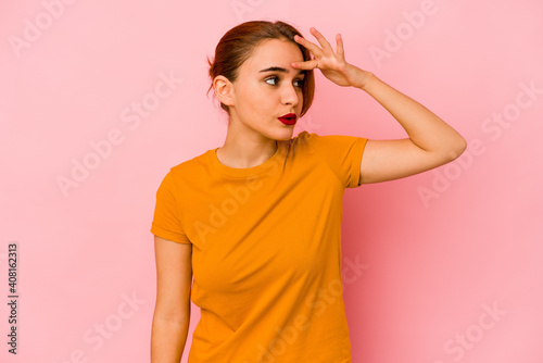 Young arab mixed race woman looking far away keeping hand on forehead.