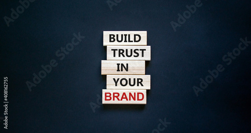 Success business process symbol. Wood blocks stacking as step stair on black background, copy space. Words 'build trust in your brand'. Business and trust brand concept.