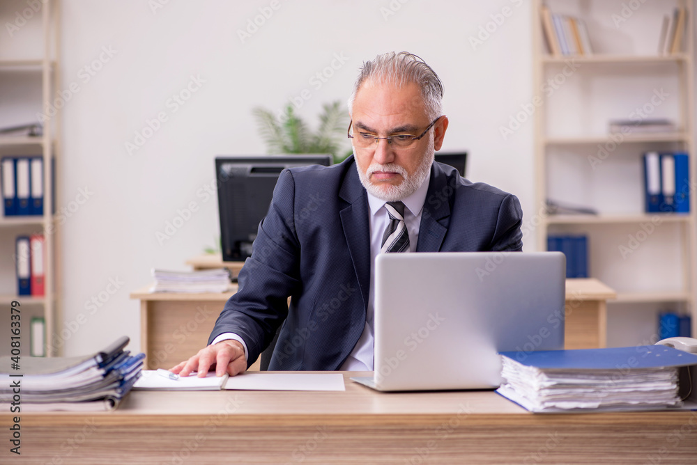 Aged businessman employee sitting in the office Aged businessman employee sitting in the office