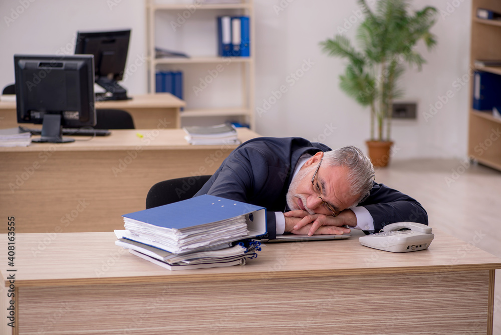 Aged businessman employee sitting in the office Aged businessman employee sitting in the office