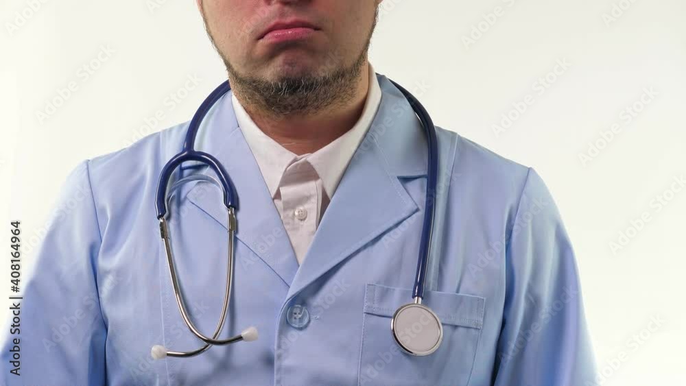 Young doctor stand and hold stethoscope in hand in blue gloves. Man in blue medical uniform on white background