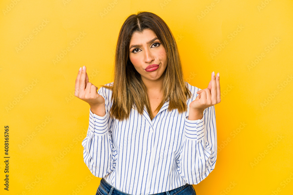Young indian woman isolated on yellow background showing that she has no money. Young indian woman isolated on yellow background showing that she has no money.