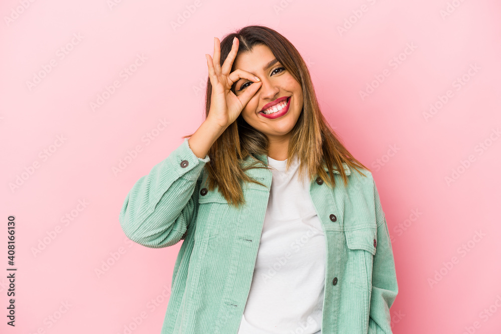 Young indian woman isolated on pink background excited keeping ok gesture on eye. Young indian woman isolated on pink background excited keeping ok gesture on eye.
