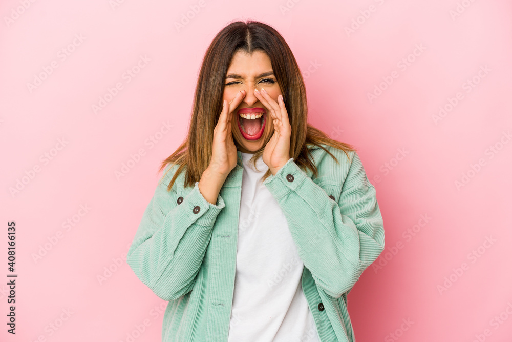 Young indian woman isolated on pink background shouting excited to front. Young indian woman isolated on pink background shouting excited to front.
