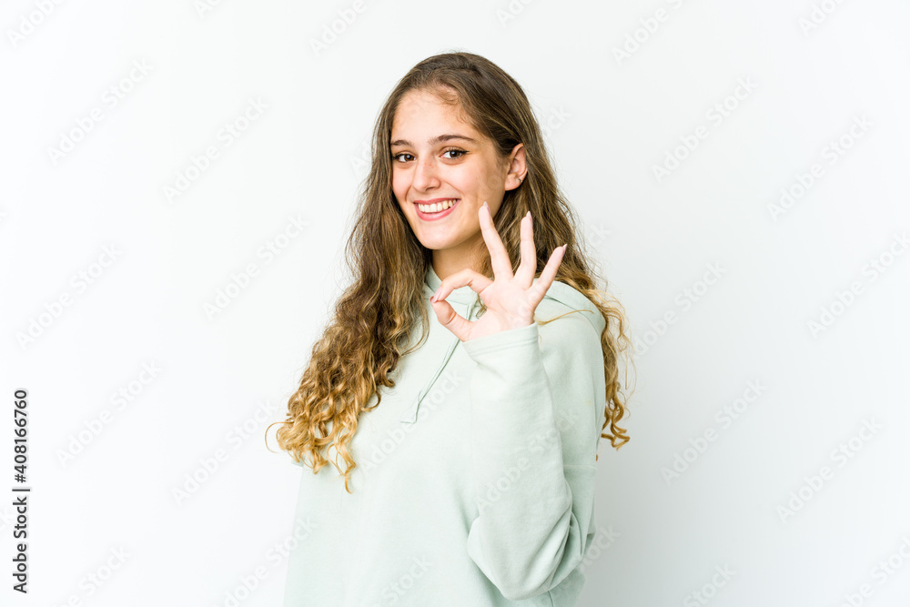 Young caucasian woman winks an eye and holds an okay gesture with hand. Young caucasian woman winks an eye and holds an okay gesture with hand.
