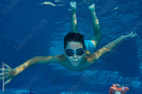 Boy diving and playing at the swimming pool