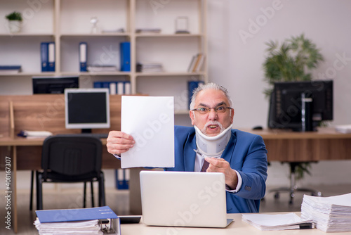 Old businessman employee after accident working in the office © Elnur