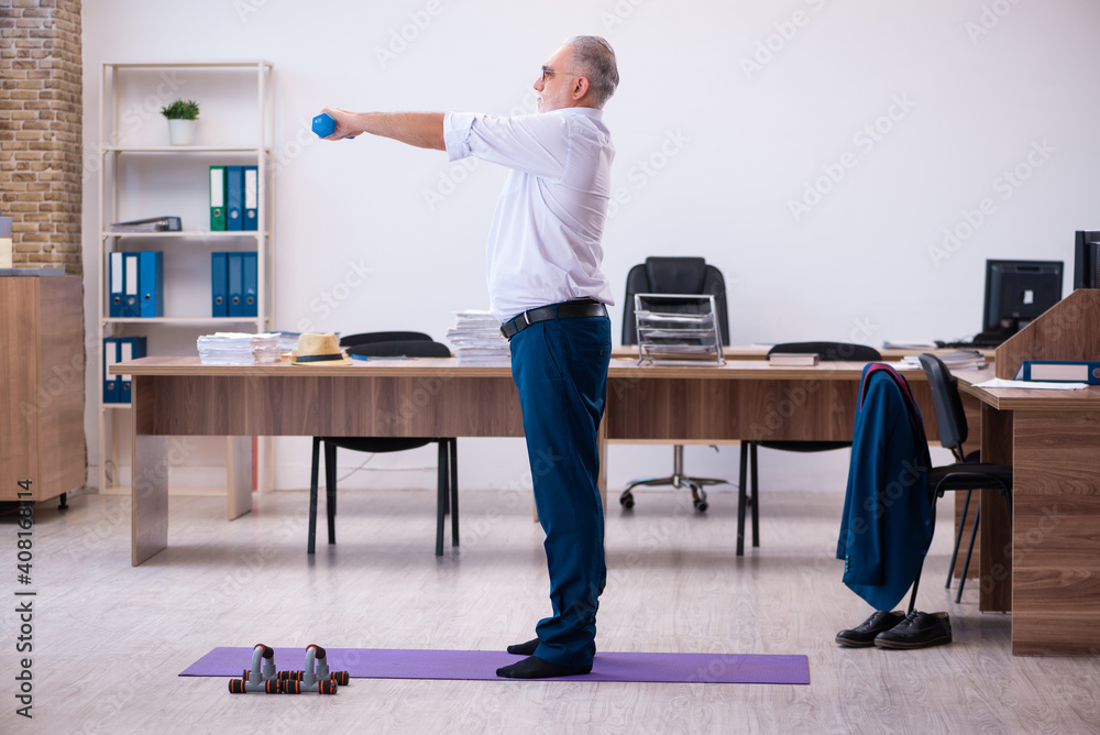 Old businessman employee doing sport exercises in the office Old businessman employee doing sport exercises in the office