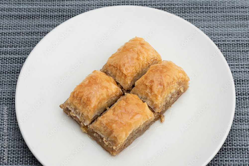 Turkish Ramadan Dessert Baklava isolated on beige plate. Turkish Ramadan Dessert Baklava isolated on beige plate.