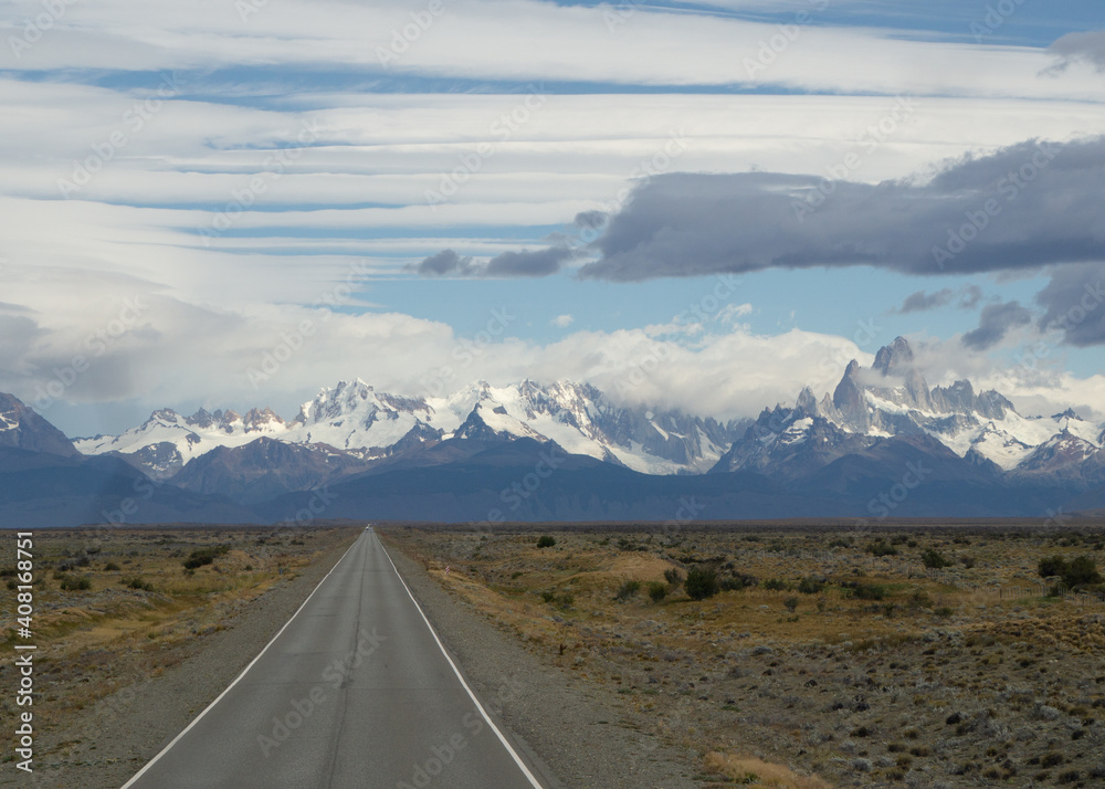 Asphalted road with the peaks of a rocky and snowy mountain on the horizon. Fitz Roy mountain in Argentina horizontal Photograph