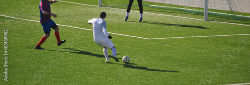Jogo de futebol com jogador em posição de remate á baliza adversária photo