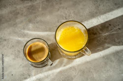 a a cup of coffee with glass of orange juice on a table. sunny morning. Gray background. Copy space for a text. Top view. High quality photo