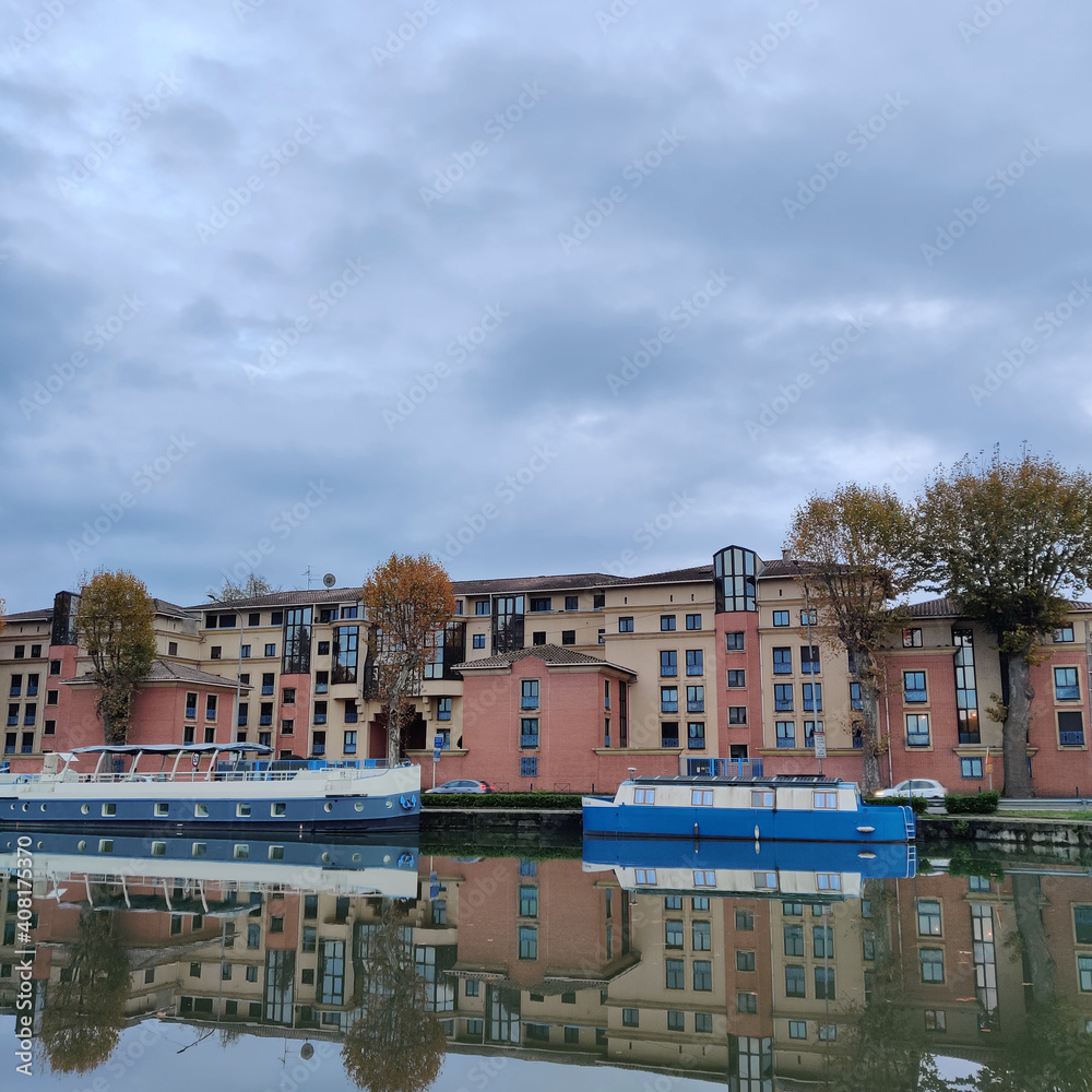 Blue steamship along the river reflected in the water during autumn, Toulouse, France