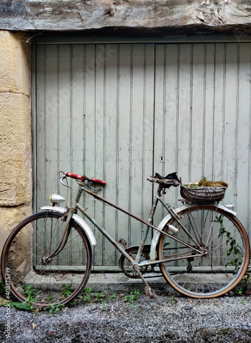 Old bicycle next to the gray garage door.