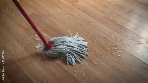 Sweeping the floor with a mop and foam. Floor care and cleaning services