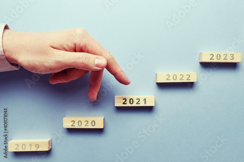 The concept of success and growth from year to year. Hand above the asbract staircase