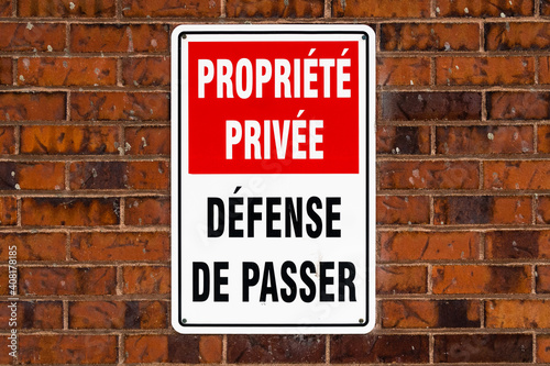 Warning sign on a brick wall (Translation : "private property, no trespassing")