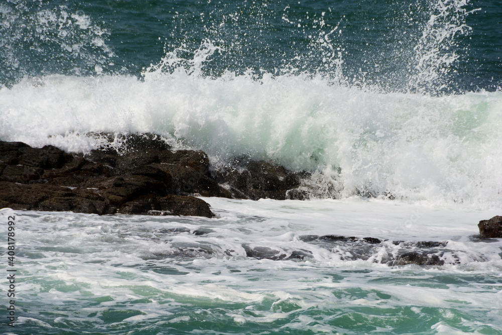 Fototapeta premium 岩に当たって砕ける波