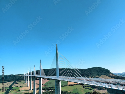 A summer panorama of a great white cable bridge. Bridge crossing the valley.  Natural panoramic view. Highest bridge. Bridge over the river