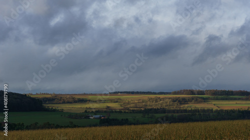 German landscape in Eifel with fields and a farm building on sunny winter day