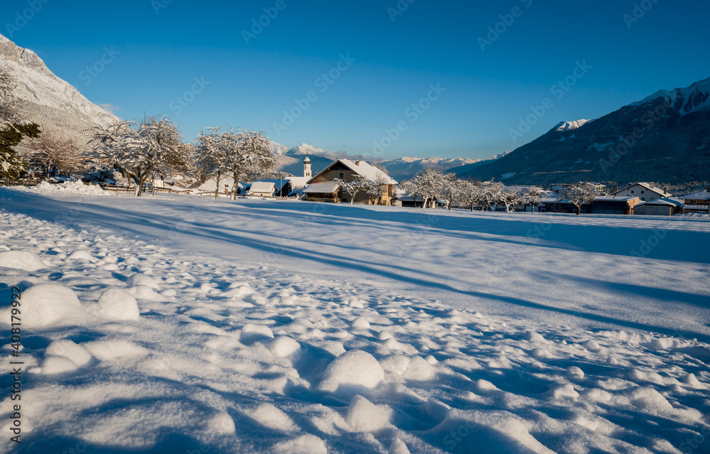 Idyllic winter landscape with snow covered village church in Austrian alps, Wildermieming, Tirol, Austria