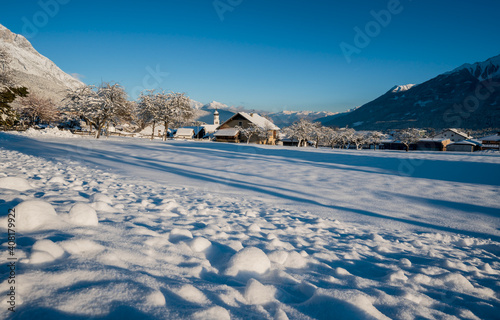 Idyllic winter landscape with snow covered village church in Austrian alps, Wildermieming, Tirol, Austria © Loes Kieboom