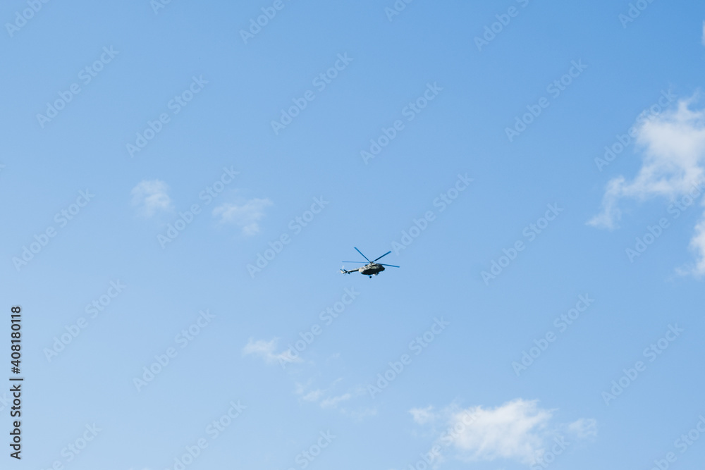 helicopter on a background of blue sky with clouds