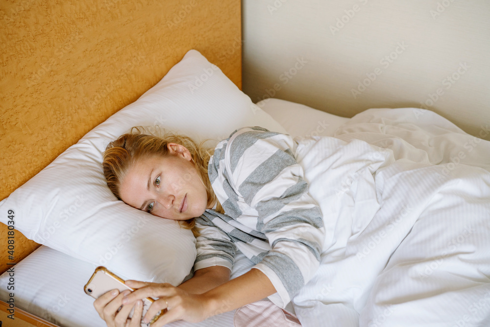Woman using her phone in bed Woman using her phone in bed