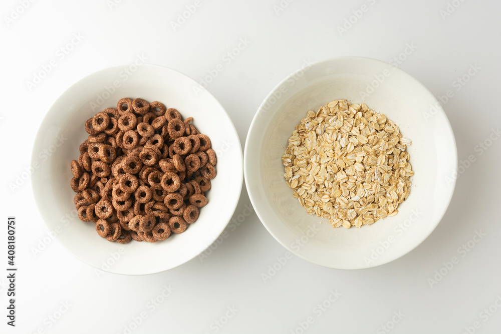 Breakfas food. Rolled oats and chocolate rings in bowls on white background, top view Breakfas food. Rolled oats and chocolate rings in bowls on white background, top view