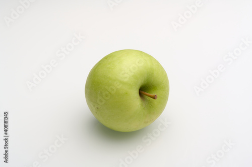 Fresh green apple on a white surface