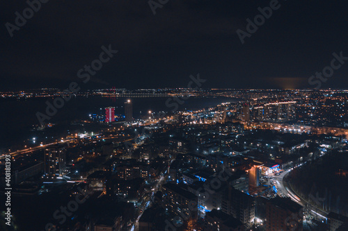 Drone view at night, with illuminated streets and dark sky. Beautiful cityscape