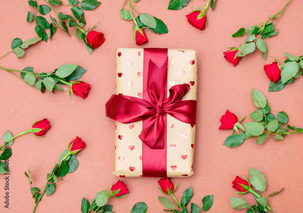 Bouquet of red roses and gift box on pink background Bouquet of red roses and gift box on pink background