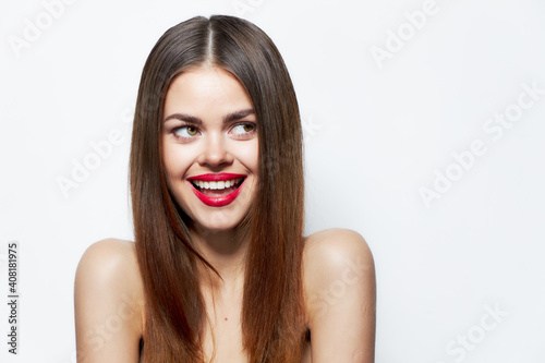 Woman with bare shoulders Laughs and looks away lipstick background