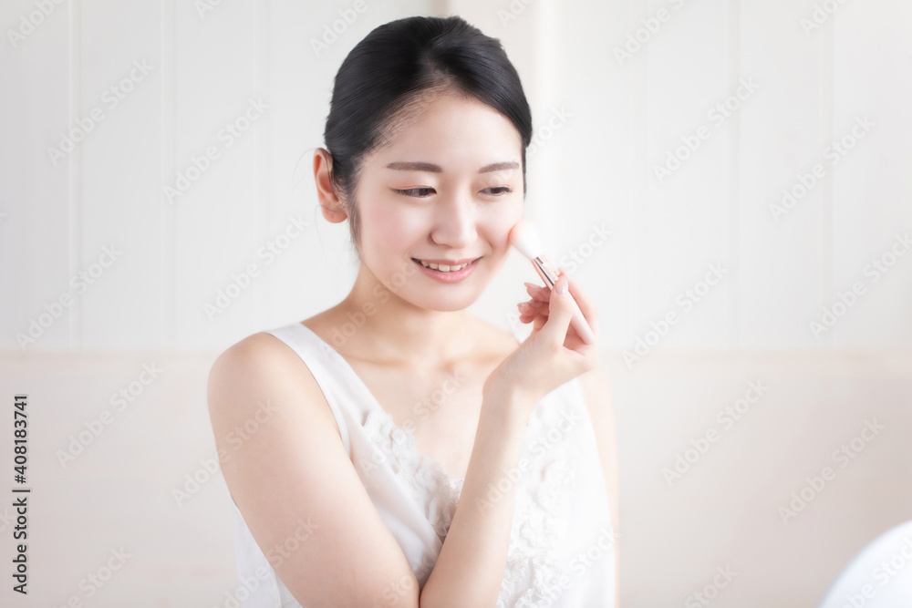 チークをつける女性
チークをつける女性