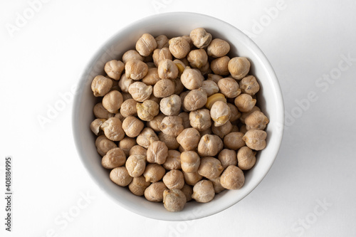 Top view of ceramic pot with uncooked chickpeas. Isolated on white background
