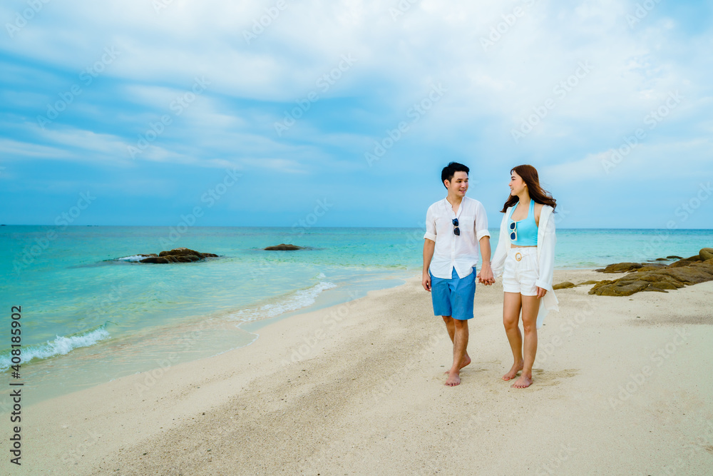 happy young couple walking on sea beach at Koh MunNork Island, Rayong, Thailand