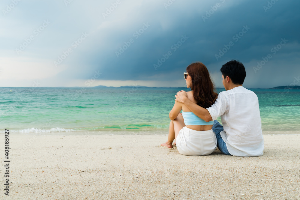 happy young couple sitting on sea beach at Koh MunNork Island, Rayong, Thailand happy young couple sitting on sea beach at Koh MunNork Island, Rayong, Thailand