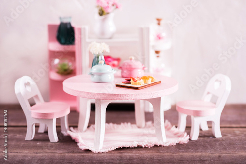 miniature table with h chairs in the living room, living room interior made of wood and plants, minimalistic concept. Miniature Wooden Toy Furniture for Children © elena_siberia