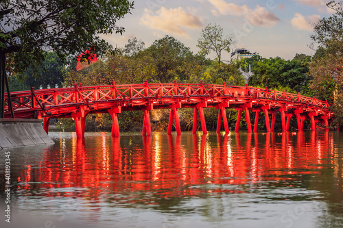 Hanoi Red Bridge at night. The wooden red-painted bridge over the Hoan Kiem Lake connects the shore and the Jade Island on which Ngoc Son Temple stands photo