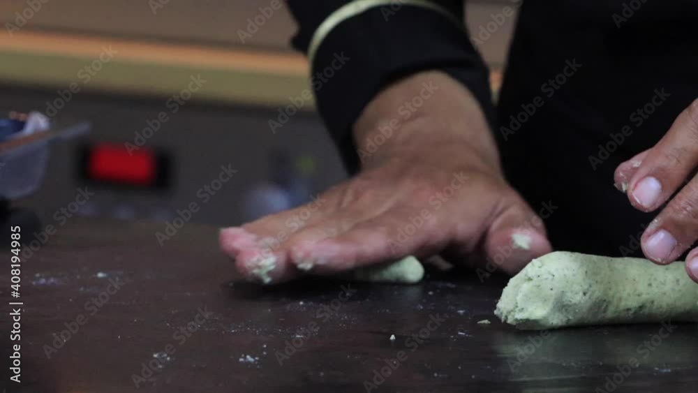 An experienced chef in a professional kitchen prepares the dough , with flour. . High quality FullHD footage An experienced chef in a professional kitchen prepares the dough , with flour. . High quality FullHD footage