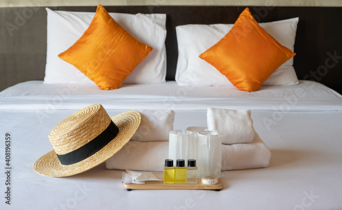 Set of hotel amenities (such as towels, shampoo, soap etc.) on the bed. Hotel amenities is something of a premium nature provided in addition to the room when renting a room.