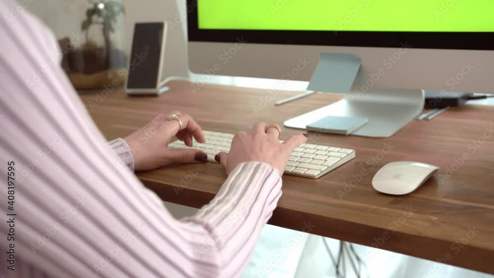 Woman is working in home office in front of a computer with green screen. Female hands typing on computer keyboard. Advertise Concept for Website, Application, Business and Social networks. Woman is working in home office in front of a computer with green screen. Female hands typing on computer keyboard. Advertise Concept for Website, Application, Business and Social networks.