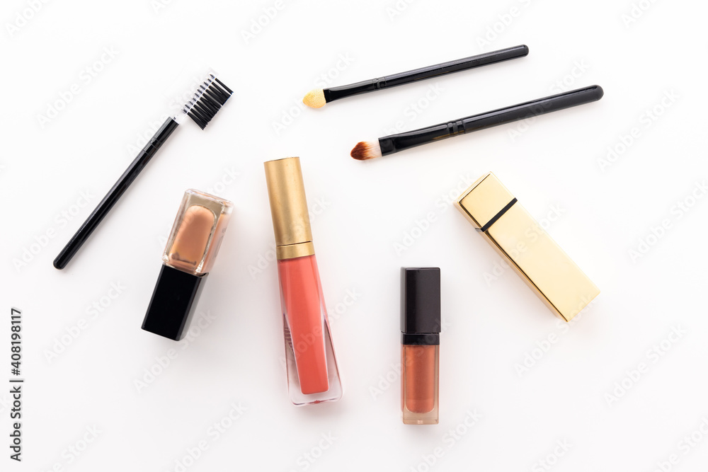 Obraz premium Plenty of makeup on the white table with eyelash brush, eye shadow, lipstick.