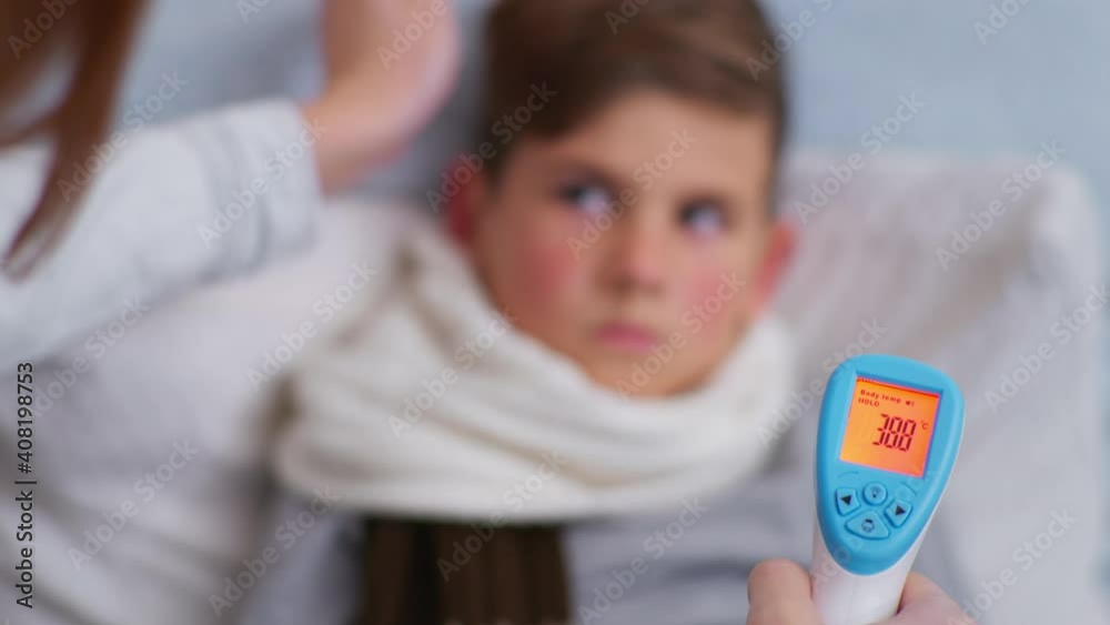pandemic, caring female parent measures Celsius heat to young child with non-contact thermometer, close-up pandemic, caring female parent measures Celsius heat to young child with non-contact thermometer, close-up