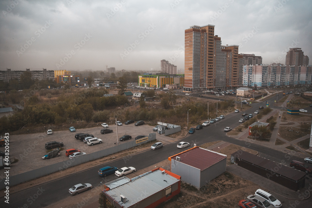 Fototapeta premium City view with modern architecture and a frightening gloomy thunderstorm sky with dark clouds