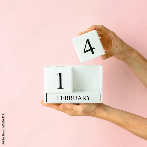 Female hands is holding monthly date calendar with 14 February Happy Valentine’s Day