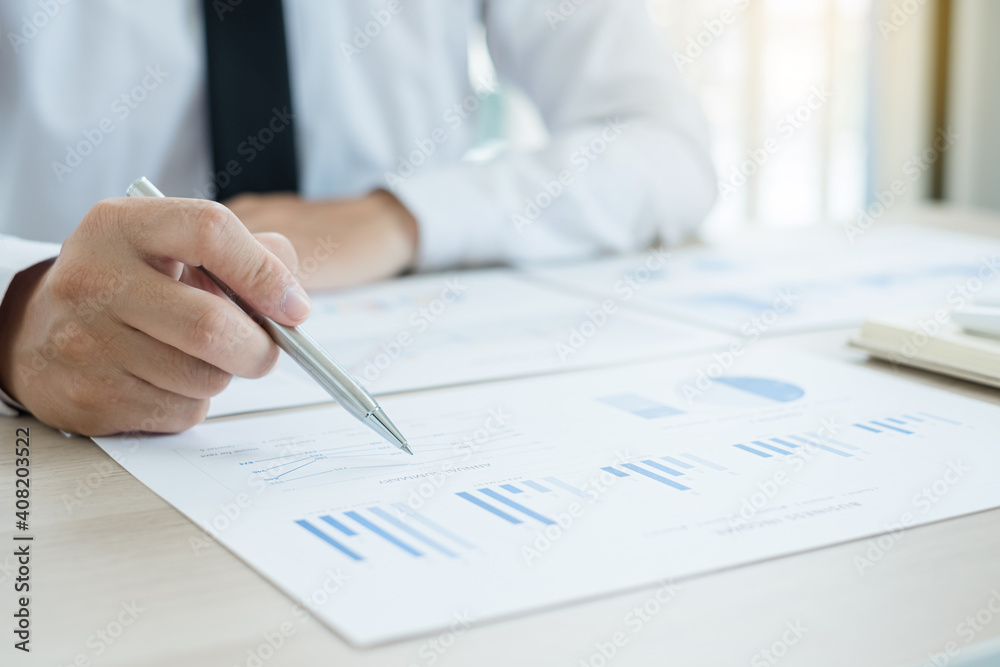 The businessman hand sits at their desks and calculates financial graphs showing the results of their investments planning the process of successful business growth
