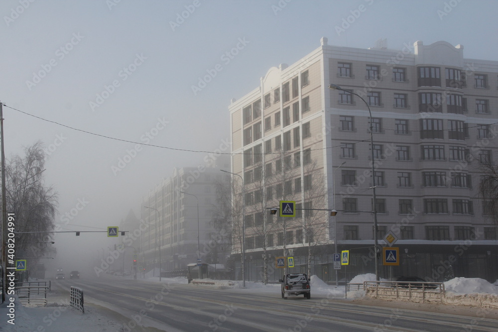 Streets of Khanty-Mansiysk city in Russia in severe frost and fog. At minus 45 degrees the streets are drowning in fog.