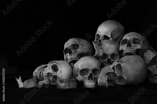 Картината върху платно The pile of old skulls put on black cloth and black background